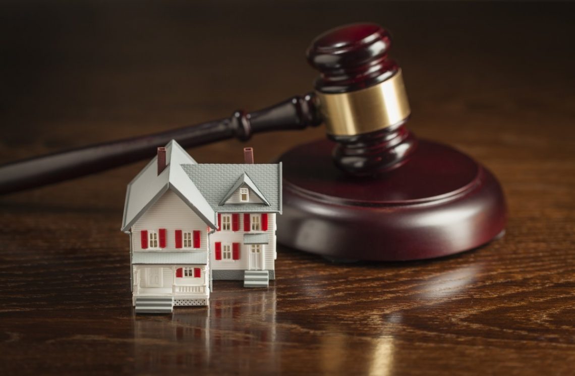 model of home with judges gavel next to it