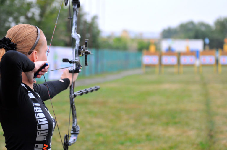 lady with archery bow aiming at targets