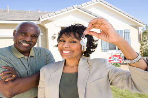 man and woman holding keys to new house