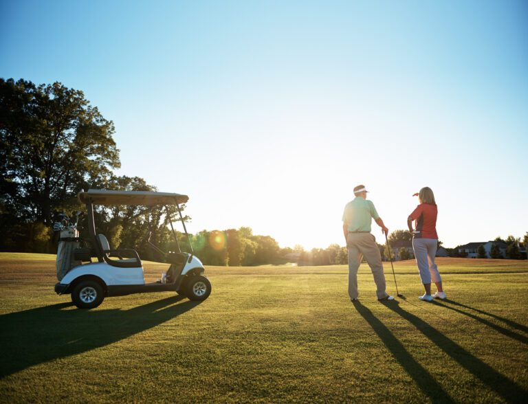 Shot of a retired couple standing on a golf green