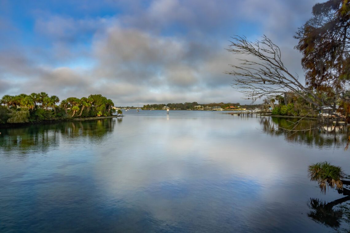 Early morning over Kings Bay with thick puffy cumulus clouds with reflections
